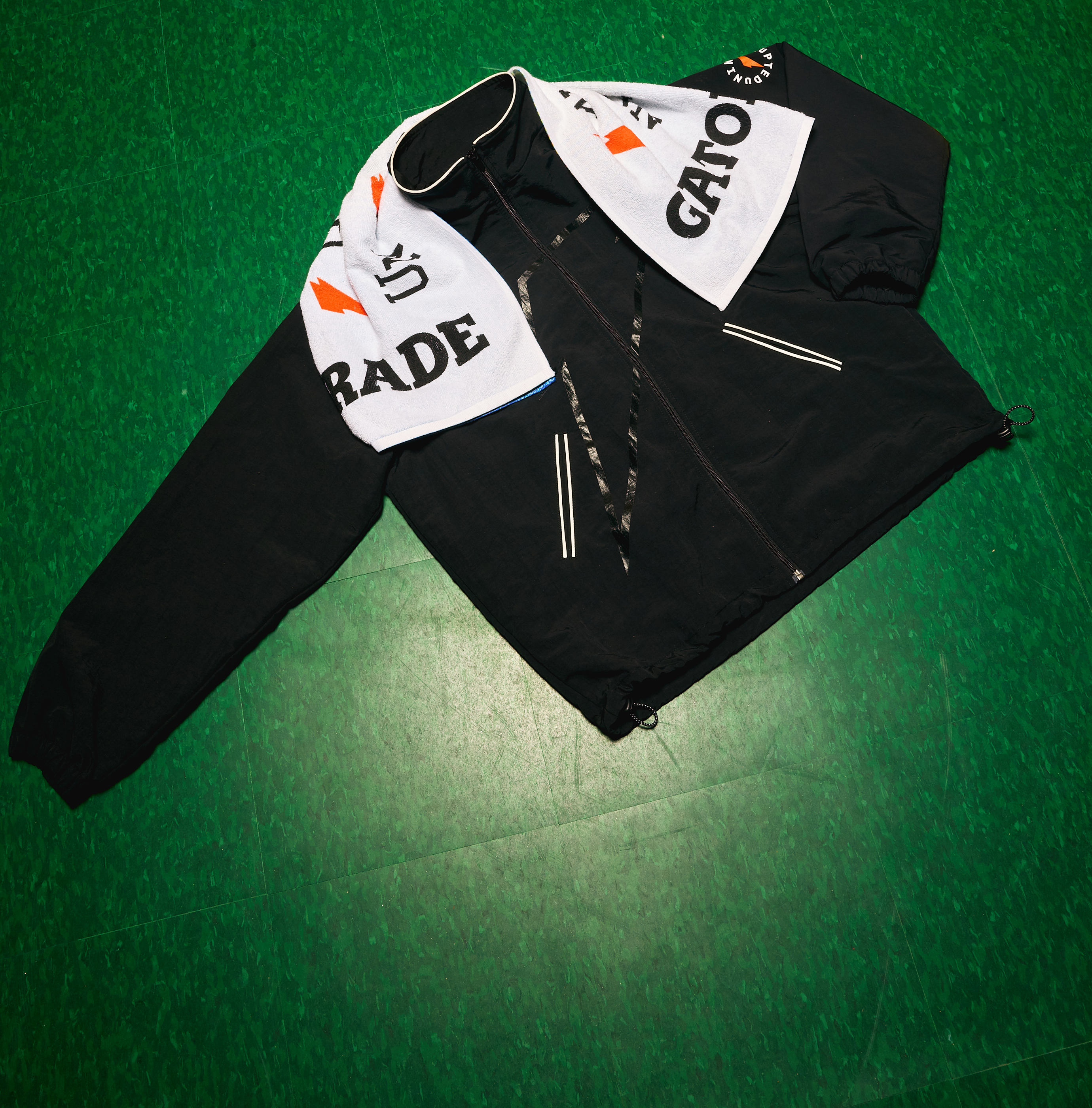 UNINTERRUPTED x Gatorade Track Jacket and Gx Towel on a green floor.