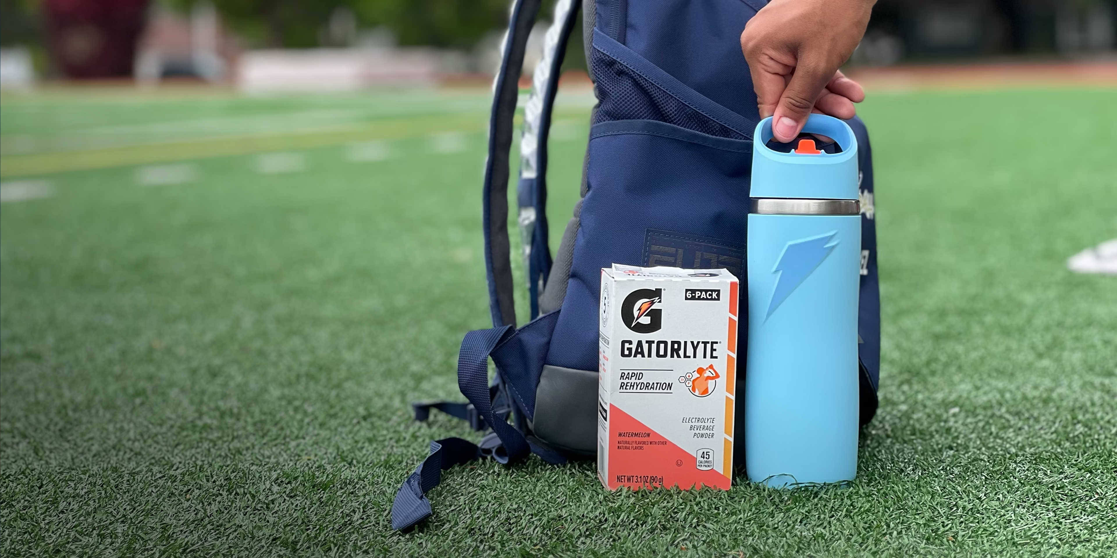 Gatorade overtime stainless steel bottle with gatorlyte sticks package and backpack on field